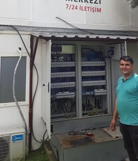 Saha çalışmasında açık şalter panosu ve yanında duran elektrik ustası